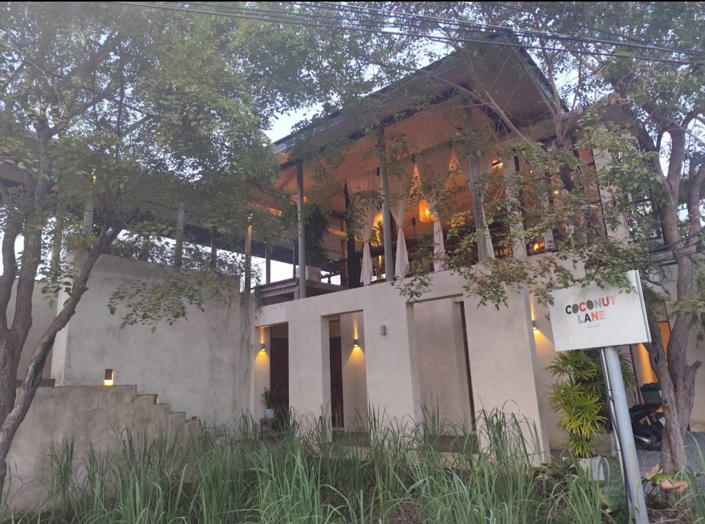 木々に囲まれたCoconut Laneの建物と看板